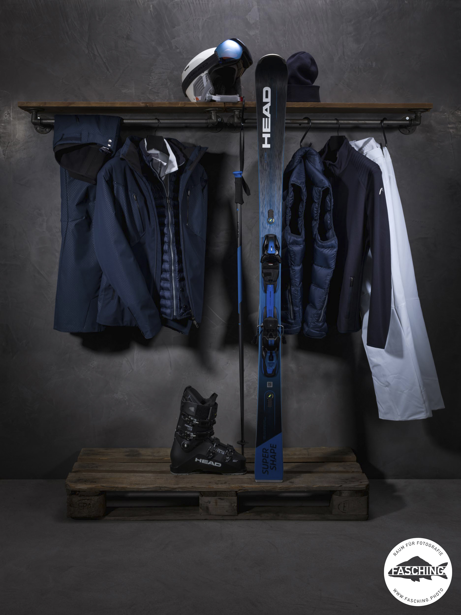Head Ski-Ausrüstung in den Farben Weiß und Blau ausgelegt hinter dunklem Hintergrund